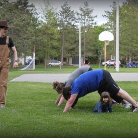 Girl passing under human bridge